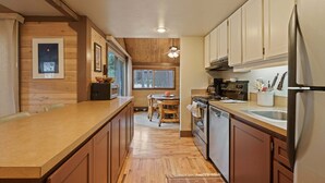 Eine moderne Küche mit Holzschränken, einem Edelstahl-Kühlschrank und einem eingebauten Backofen.