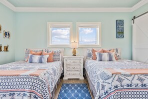 A bedroom with two beds, a dresser, a window, and a motivational quote on the wall. - Easy Breezy 4 Bedroom Home (Port Bolivar)
