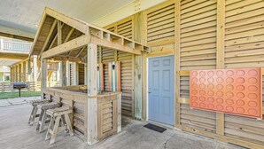 A wooden structure with a sloped roof, a door, and a wall-mounted circular object. - Easy Breezy 4 Bedroom Home (Port Bolivar)