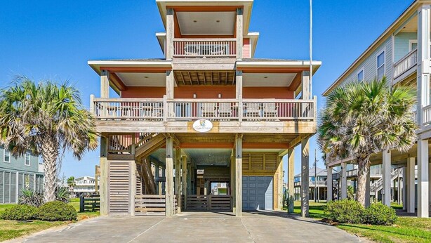 A multi-story hotel with a central atrium, balconies, and a parking area. - Easy Breezy 4 Bedroom Home (Port Bolivar)