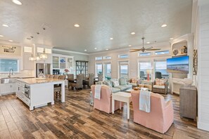 A spacious living area with a kitchen, dining space, and seating area. - Gabriels Landing 5 Bedroom Home (Port Bolivar)