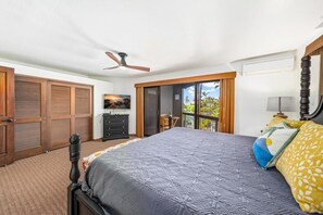 A bedroom with a bed, a ceiling fan, a dresser, a chair, and a balcony with curtains. - Big Island Kanaloa At Kona 803 1 Bedroom Condo (Kailua-Kona)