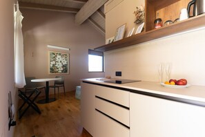 A kitchen with a wooden countertop, a sink, and a window. There is a table with chairs and a painting on the wall. - Apartment 'Ulivo' with Shared Pool, Wi-Fi and Air Conditioning (Prignano sulla Secchia)