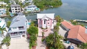 A residential area with houses, a dock, and a body of water. - Island Bay House B in Anna Maria Island (Holmes Beach)