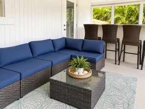 A sectional sofa, wicker chairs, and a glass coffee table with a plant centerpiece. - Private heated pool & hot tub near AMI and IMG (Bradenton)