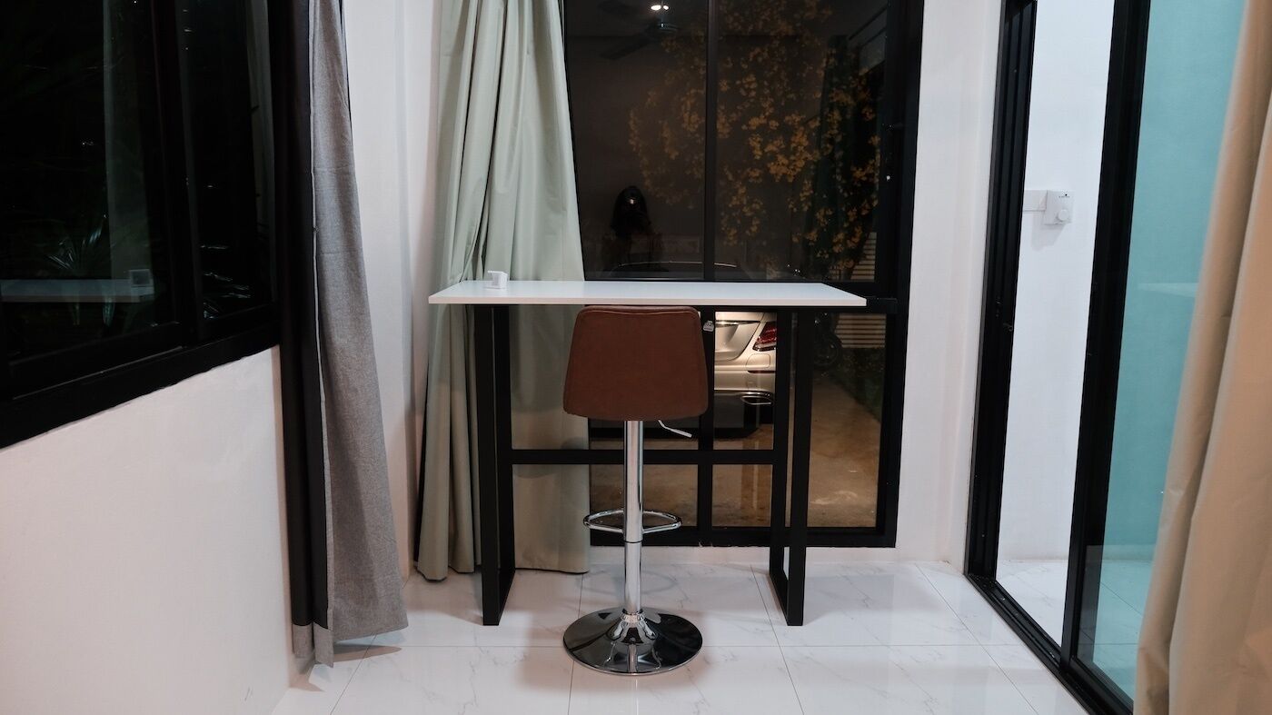 A small, modern room with a white table and a brown chair.