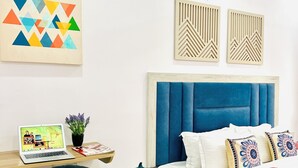 A modern bedroom with a bed, a desk, and a chair. - Moti Mini Banquet Hall Delhi (New Delhi)