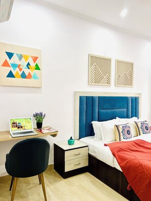 A modern bedroom with a bed, a desk, and a chair.