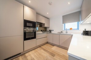 Une cuisine moderne dotée d’appareils électroménagers intégrés, d’une fenêtre offrant une belle vue et d’un design épuré et minimaliste.