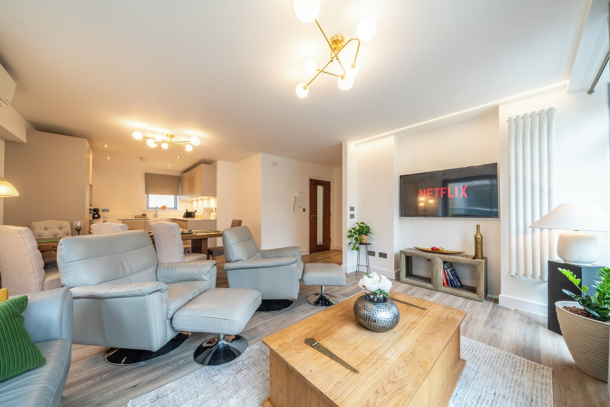 Una sala de estar moderna con un conjunto de sofá, una mesa de centro y un televisor de pantalla plana montado en la pared.