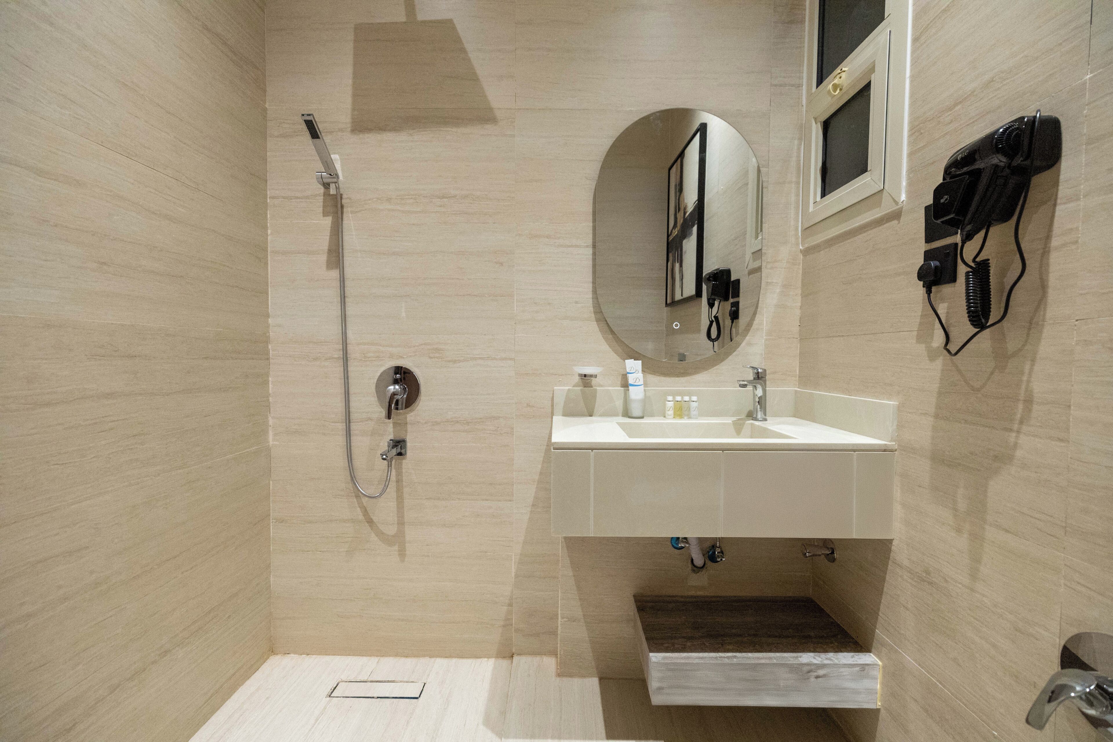 A modern bathroom with a shower, sink, and mirror.