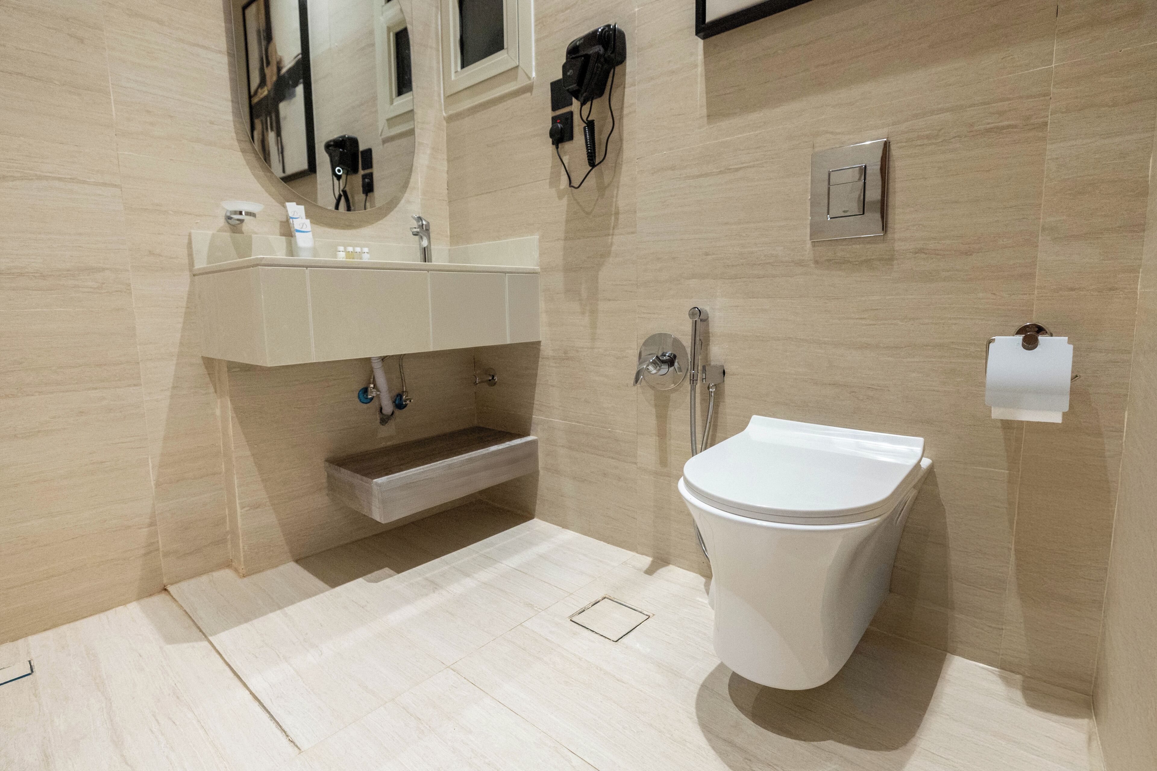 Een moderne badkamer met toilet, wastafel en spiegel.