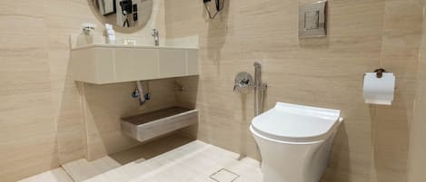 A modern bathroom with a toilet, sink, and mirror.