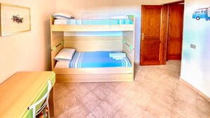 A room with a bunk bed, a small table, and a door leading to another room. - Green Garden House - Relaxation and a Private Garden in Malamurì (Malamurì)