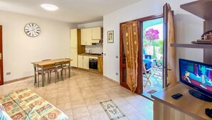 A room with a bed, a TV, a dining table, and a kitchen area. - Green Garden House - Relaxation and a Private Garden in Malamurì (Malamurì)