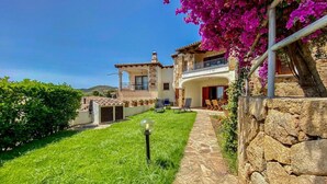 A two-story house with a stone facade, a balcony, and a well-maintained lawn. - Green Garden House - Relaxation and a Private Garden in Malamurì (Malamurì)