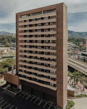 Ein mehrstöckiges Gebäude mit zeitgenössischer Architektur, das durch eine Reihe von Balkonen und große Fenster gekennzeichnet ist.