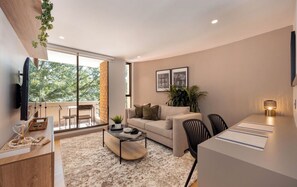 A modern living room with a sofa, coffee table, and dining area. - Live in Provenza Modern 1 BR Security (Medellín)