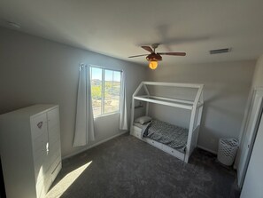 A bedroom with a bunk bed, a ceiling fan, a window with curtains, and a white dresser. - Charming  4BR/3B home with pool access near Superstition Mountains (Apache Junction)