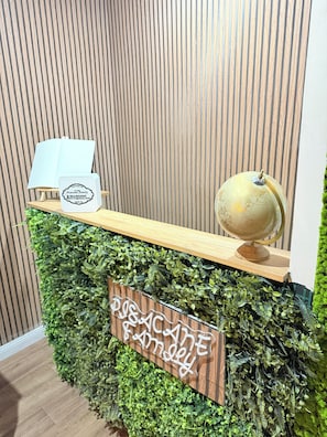 A reception desk with a wooden top, a globe, and a welcome sign.