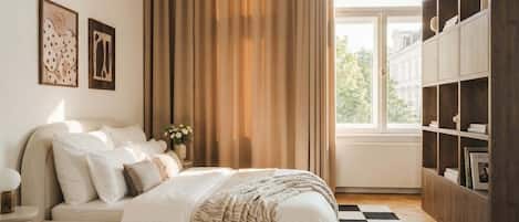 A bedroom with a bed, a checkered floor, a bookshelf, and a window with curtains.