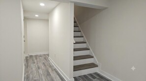 Una escalera con escalones de madera y paredes blancas.