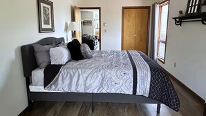 A bedroom with a bed, a wooden floor, a door, and a window. - Vacation Home. 4 Minutes to Hunter Mountain! (Hunter)