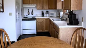 A kitchen with wooden cabinets, a white stove, a microwave, and a coffee maker. - Vacation Home. 4 Minutes to Hunter Mountain! (Hunter)