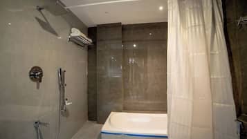 A modern bathroom with a bathtub, shower, and a ceiling-mounted air conditioning unit.