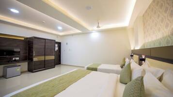 A hotel room with a bed, a desk, a wardrobe, and a television.