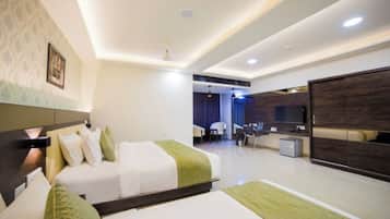 A hotel room with two beds, a desk, a chair, and a television.