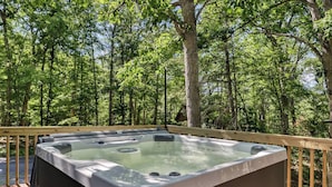 A hot tub on a wooden deck surrounded by a forest. - Whimsical Cabin: Secret Room, Pizza & HOT TUB (Basye)