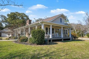 A single-story house with a covered porch and a chimney. - Peaceful 4-bedroom cottage in Oyster Bay Golf Community (Sunset Beach)