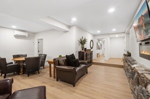 A spacious living area with a fireplace, leather furniture, and a stone accent wall.