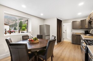 Una cocina moderna con comedor, ventanas amplias y vistas al exterior.