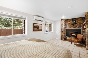 Un dormitorio con una cama grande, una chimenea y vistas al exterior.