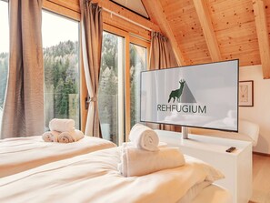 Una camera d'albergo con un letto, una televisione e una finestra con tende.
