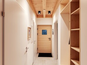 A narrow hallway with wooden doors and a tiled floor, leading to a room with a wooden door and a small window. - Beautiful private villa for 8 people with TV, terrace and pets allowed (Lachtal)
