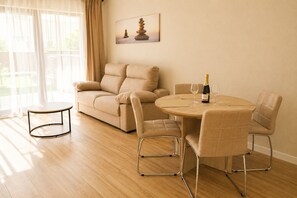 Una sala de estar con un sofá, una mesa redonda y una botella de champán.