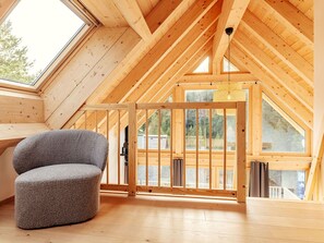 A room with a sloped ceiling, wooden beams, a window, and a chair. - Stunning  villa for 2 people with WIFI, TV, terrace and pets allowed (Lachtal)