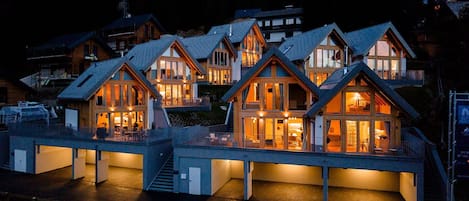 A multi-story lodge with large windows and a covered outdoor area.
