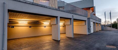 Een modern gebouw met meerdere parkeerplaatsen en een overdekte doorgang.