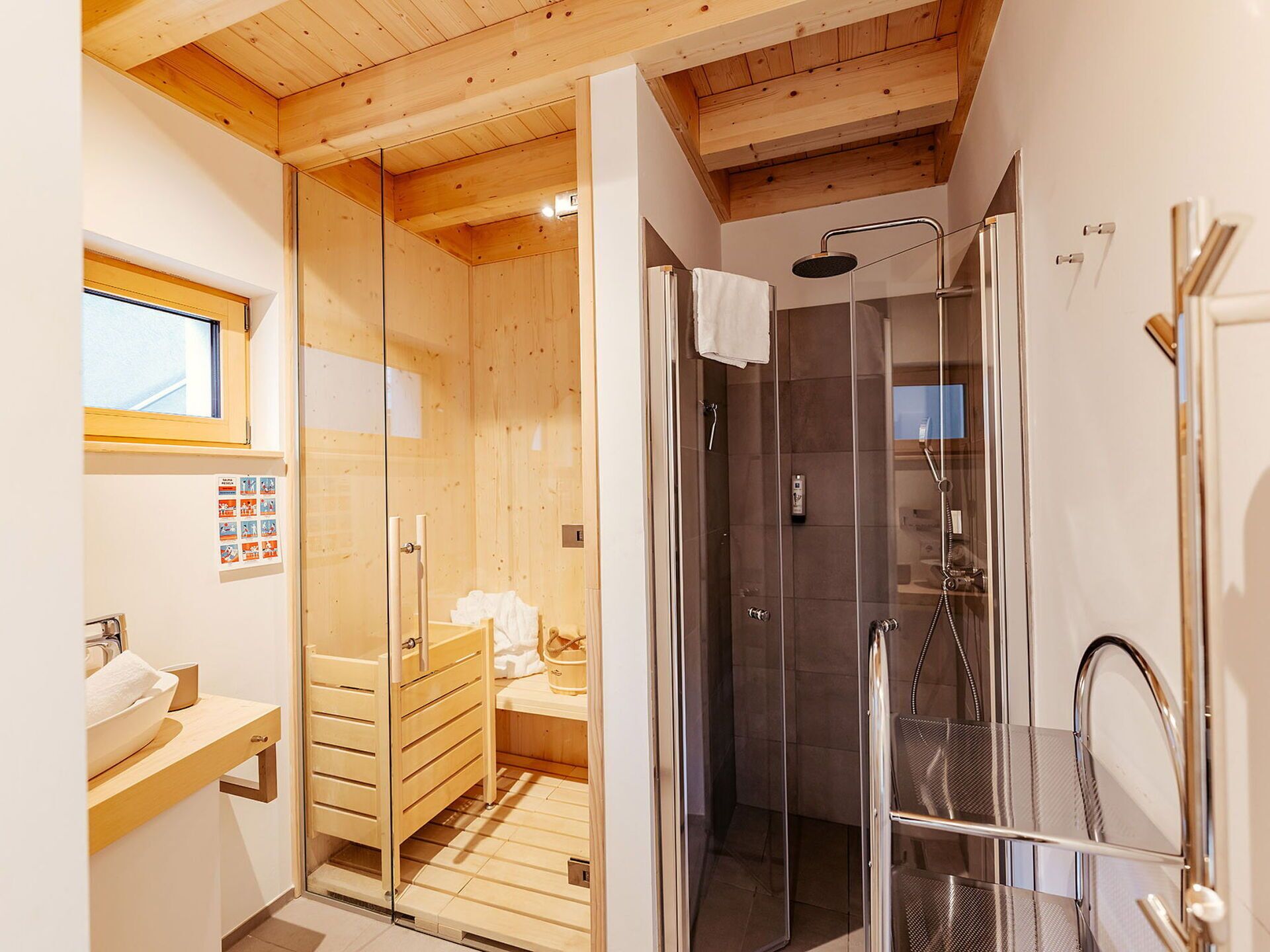 Une salle de bain moderne avec une douche à parois de verre, un plancher en bois et un plafond en bois.