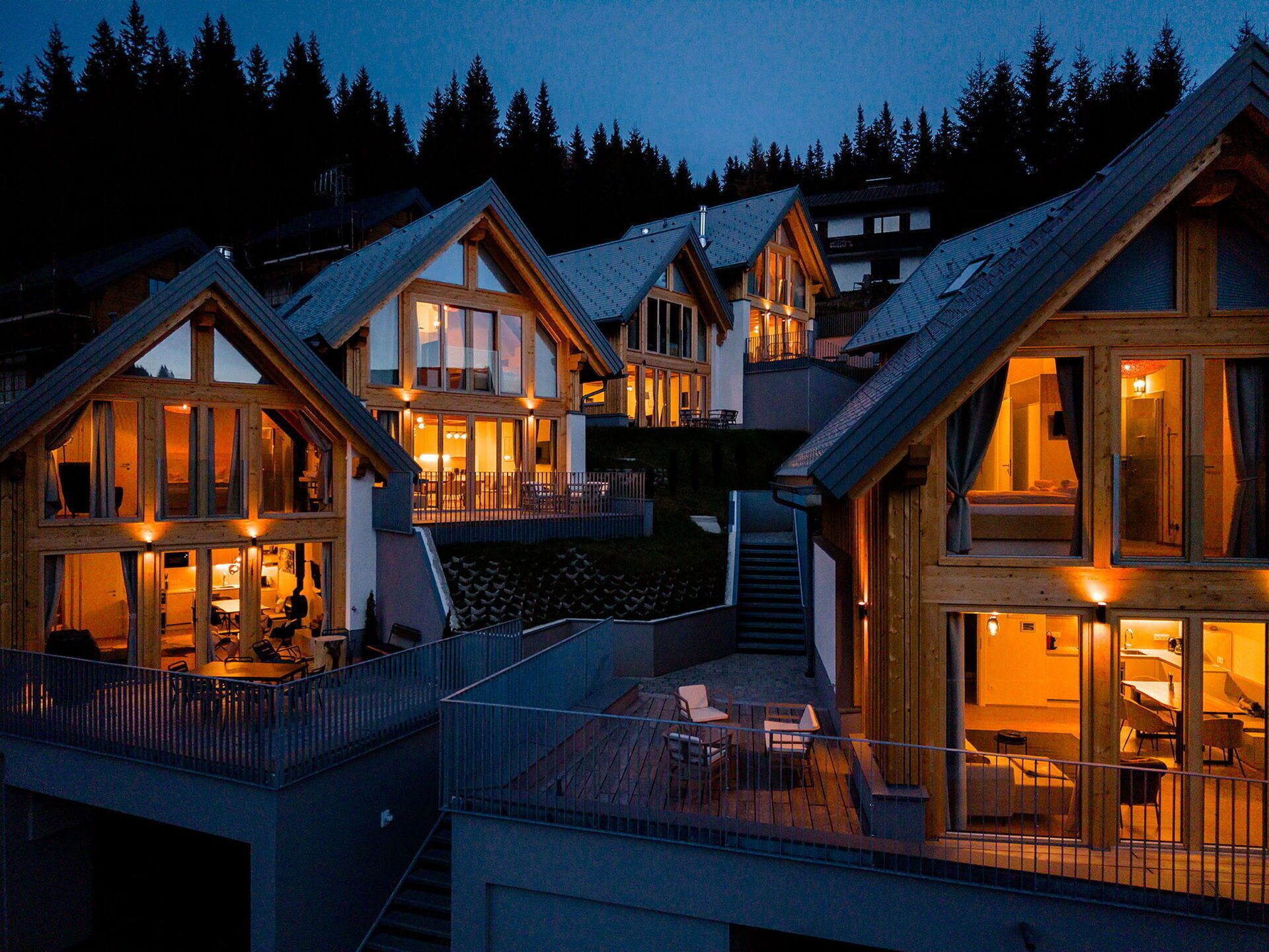 Eine mehrstöckige Lodge mit großen Fenstern und Balkonen, umgeben von Bäumen.