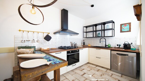 A modern kitchen with white tiled backsplash, wooden countertops, a gas stove, an oven, and a dishwasher. - Solemar Sicilia - Stella Marina (Santa Flavia)
