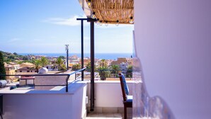 A balcony with a view of a coastal town, a pergola with hanging lights, and a metal railing. - Solemar Sicilia - Stella Marina (Santa Flavia)