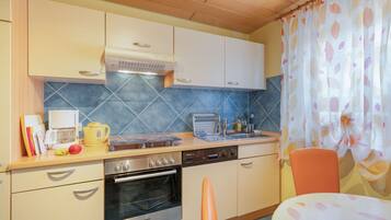 A compact kitchen with a microwave, stove, oven, and a sink.