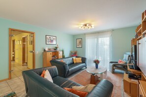 Een woonkamer met een zithoek, een salontafel en een televisie.