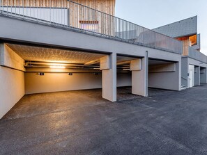 Uma estrutura de estacionamento em vários níveis, com pilares de concreto e telhado inclinado.