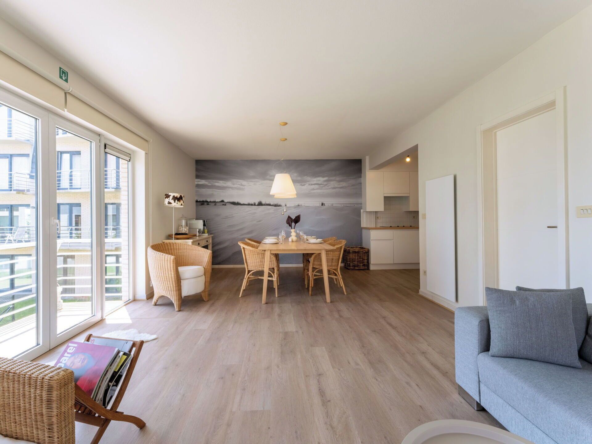 A modern living room with a dining area, a large window, and a view of the city.